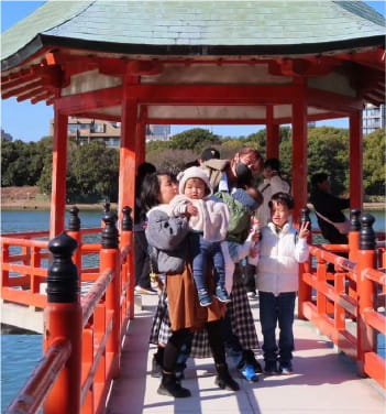 神社の赤い橋で観光を楽しむ美容師グループ