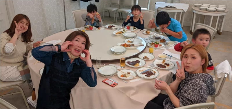 美容師やその家族が円卓で食事を楽しむ様子